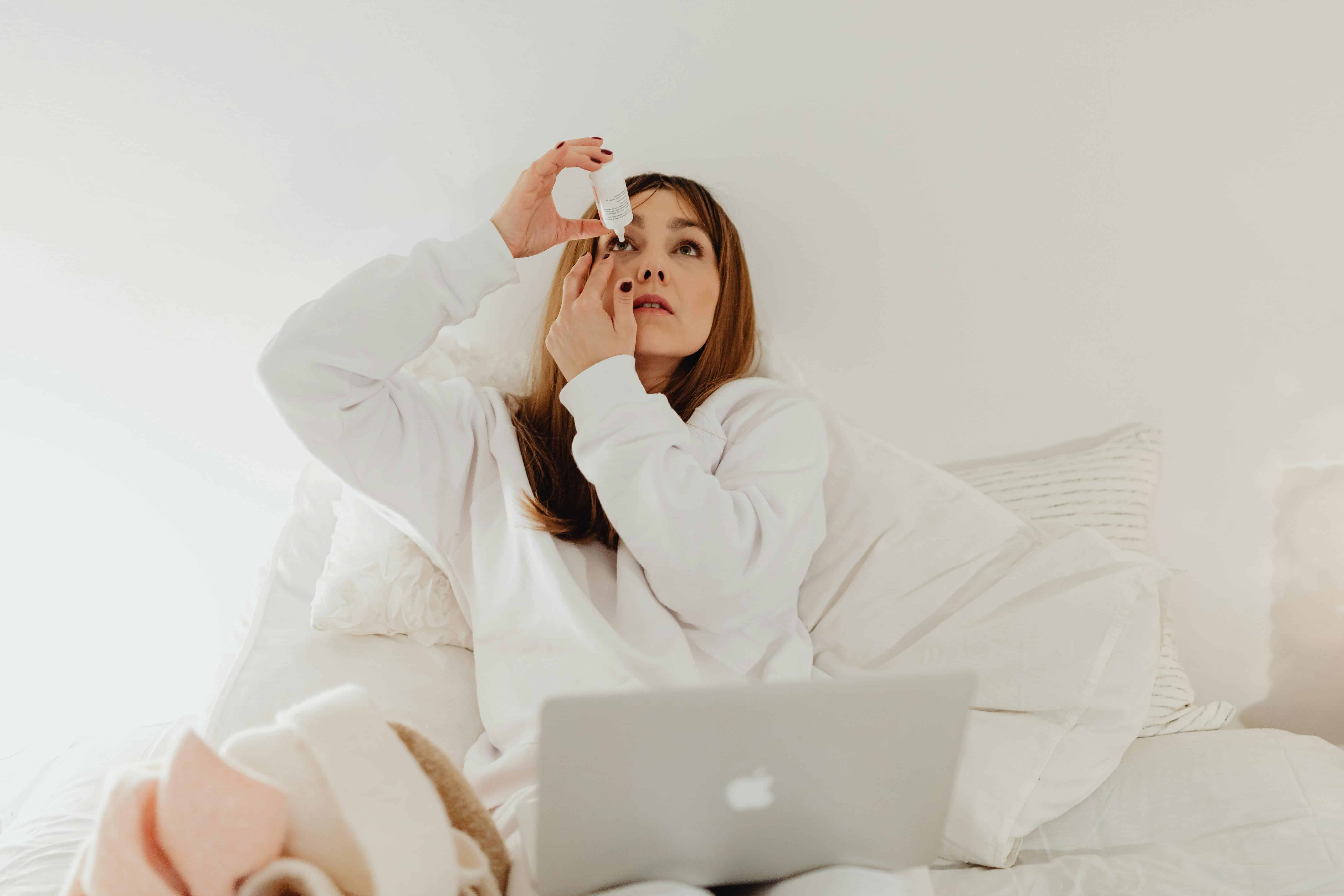Person applying eye drops to relieve dry, irritated eyes